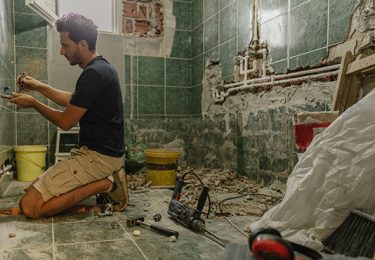 Photo of a young man renovating bathroom by himself